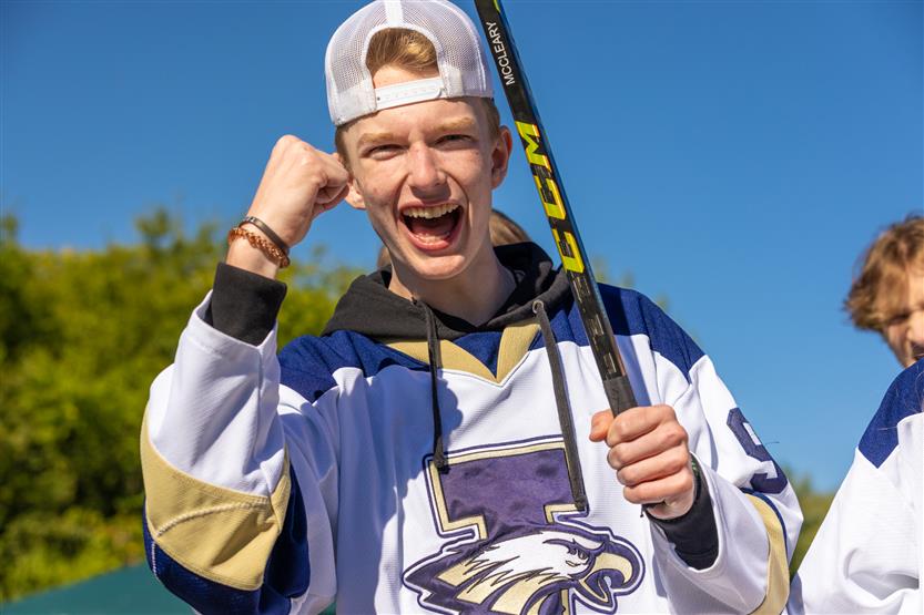 A boy cheers while riding on a homecoming float